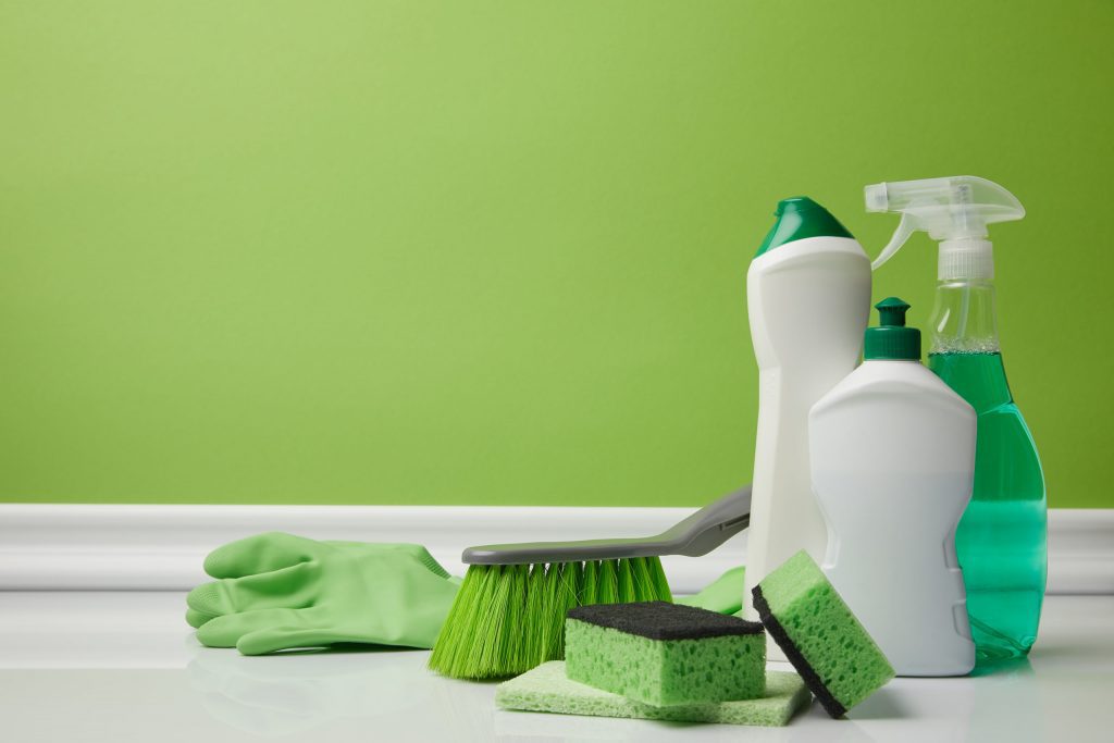 brush-and-domestic-supplies-for-spring-cleaning-on-green