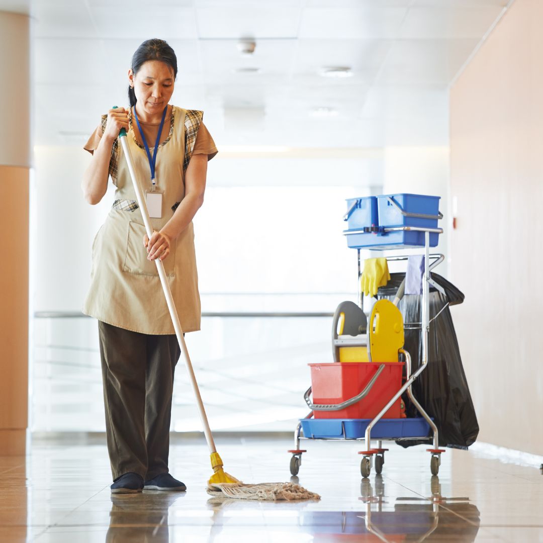 Office cleaning professional disinfecting desk